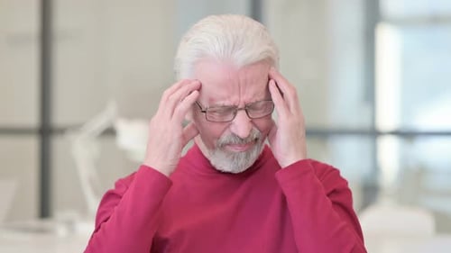 Senior Man Massages Temples Appearing to have Headache