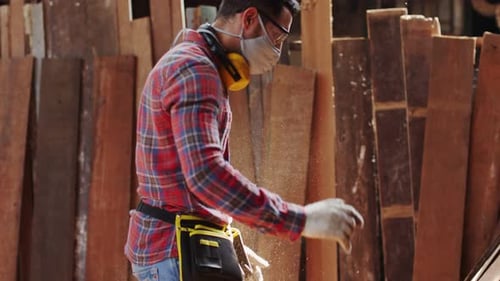 Woodworker in Mask Moves Wooden Planks