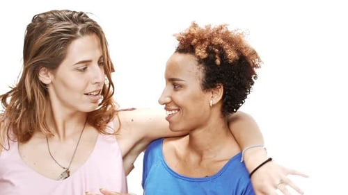 Two Young Women Smiling and Embracing in Studio