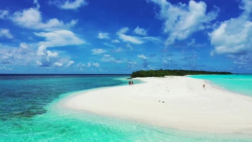 Young girls walking along the sandbar in the tropical ocean. Aerial. Empty white beach in Maldives