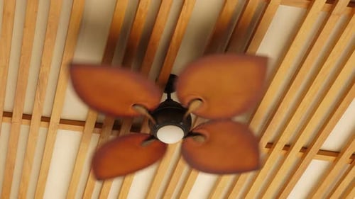 Brown Ceiling Fan Rotating Under Wooden Ceiling