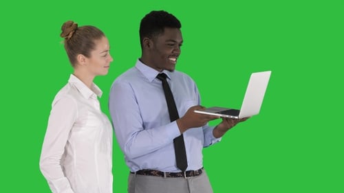 Colleagues Discussing Data on Laptop with Green Screen