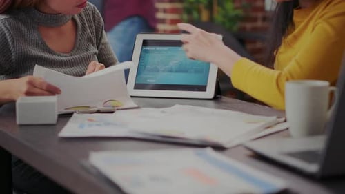 Adults Analyze Report Using Tablet and Laptop