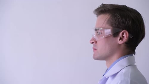 Profile View of Young Handsome Man Doctor Thinking While Wearing Protective Glasses