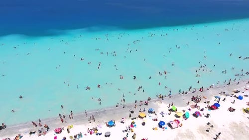 Menschen schwimmen im Urlaub am weißen Sandstrand des klaren tropischen türkisfarbenen hellblauen Meeres