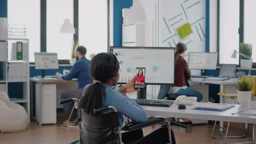 Woman in Wheelchair Attends Virtual Meeting in Office
