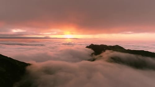 Majestic Mountains Emerging from Clouds at Sunrise