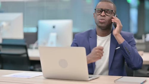 African Businessman Talking on Smartphone in Office