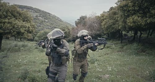 Trupp voll bewaffneter Kommandosoldaten während des Kampfes in einer Waldlandschaft