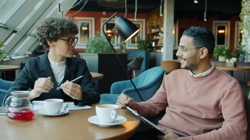 Businesspeople Man and Woman Talking During Informal Meeting in Cafe