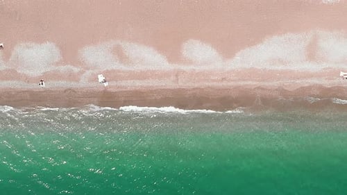 Clear turquoise sea waves breaking on sandy beach, splashing and creating white foam