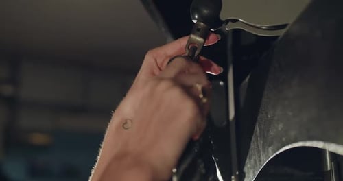 Mãos femininas consertando uma corda esportiva no simulador e puxando-a em uma academia