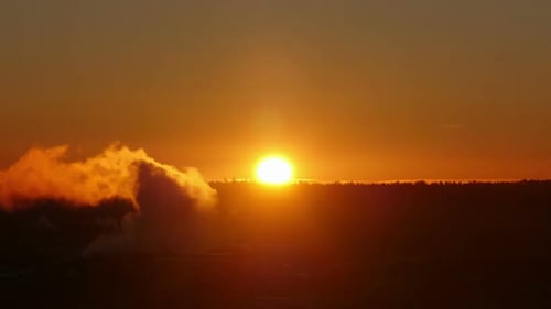 Industrial Sunrise Over Factory Emissions