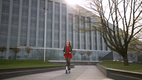 Woman Riding Electric Scooter in Urban Setting