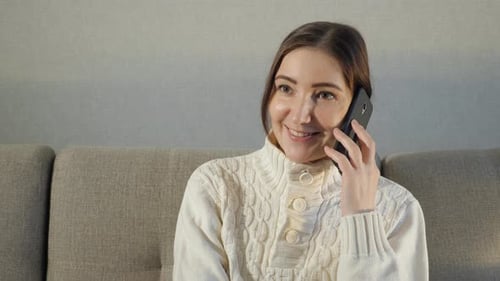 Woman with brown hair talking on cell phone