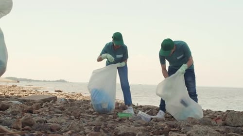 Junge Freiwillige sammeln Müll an der Küste des Ozeans