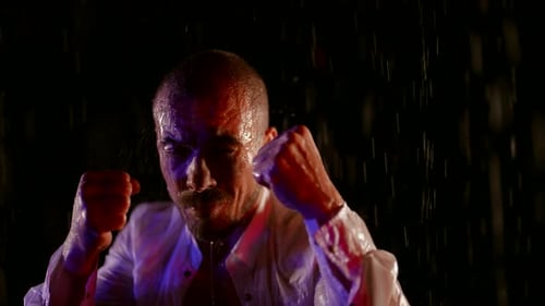 Man in Rain Clenched Fists at Night
