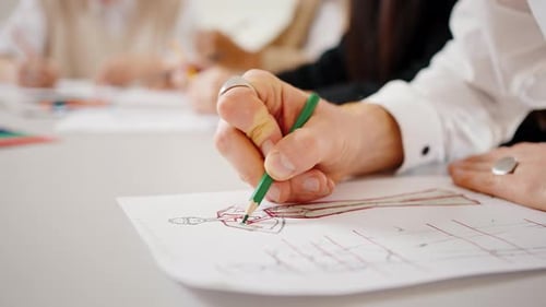 Close Up of Unrecognizable Fashion Designer Painting Dress Sketch Creating New Clothes Collection at