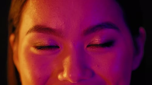 Woman's Face Close-Up in Pink and Orange Light