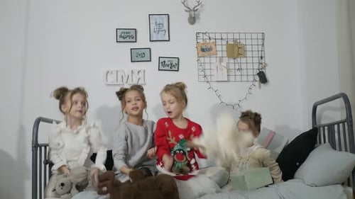 Playful Children Throw Stuffed Animals on a Bed