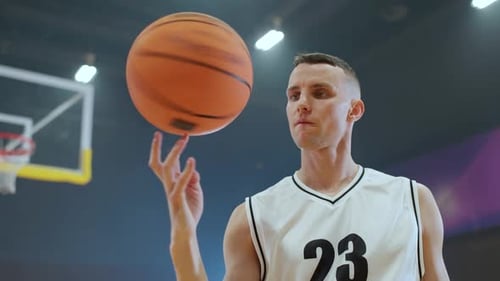 Sport Lifestyle Young Man Player Shows a Trick with a Spinning Basketball on His Finger and Looking