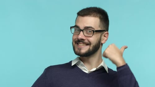 Nahaufnahme eines aufgeregten bärtigen Mannes mit Brille, der mit erhobenem Daumen von unten springt und Zustimmung zeigt