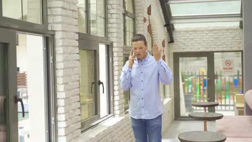 Young man making angry phone call in cafe.