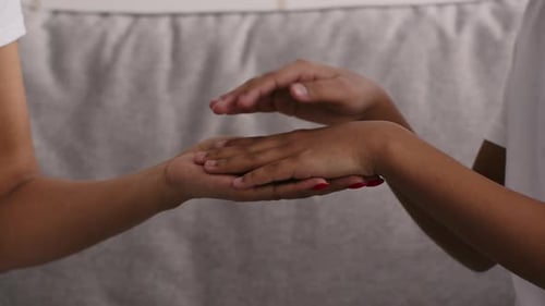 Two People Hold Hands in Comforting Gesture