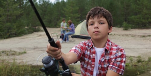 Boy Fishing in a Lake at Campsite