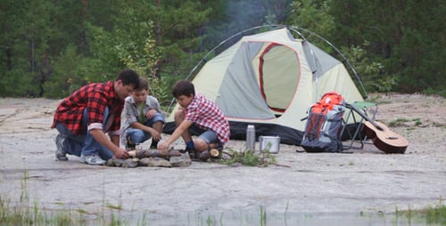 Man and Boys by Campfire in Nature
