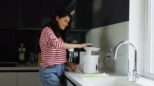 Femme préparant du jus de céleri dans la cuisine