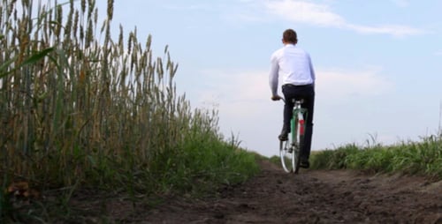 Man Rides Bicycle on Dirt Path