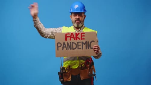Construction Worker Holding Protest Sign About Pandemic