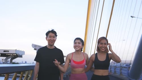 Young Female and Male Athletes at Bridge Talking and Walking