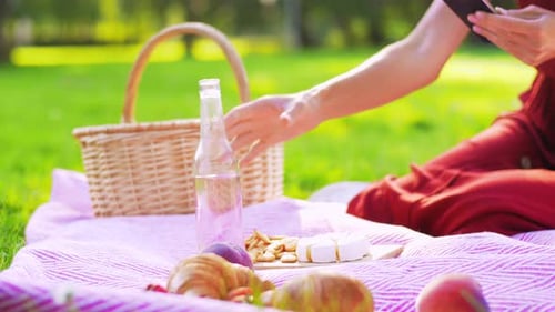 Happy Woman with Smartphone on Picnic at Park