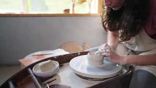 Girl Potter travaillant sur un plat en argile