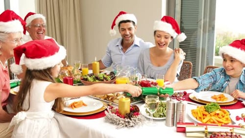 Festive Family Pulling Christmas Crackers Together at Dinner