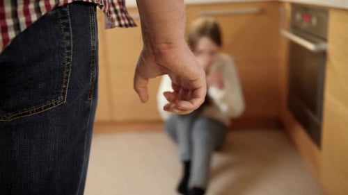Clenched Fist with Distressed Woman on Kitchen Floor