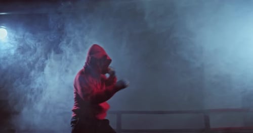 Boxer Shadow Boxing at Night in Boxing Ring