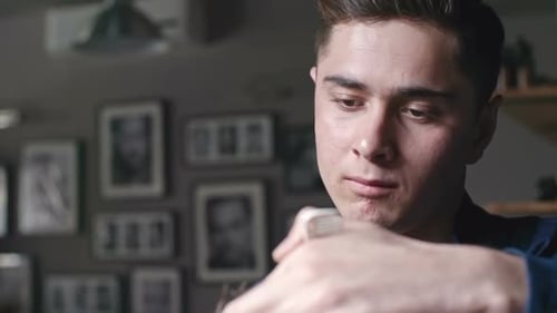 Young Man Combs His Hair in Barber Shop