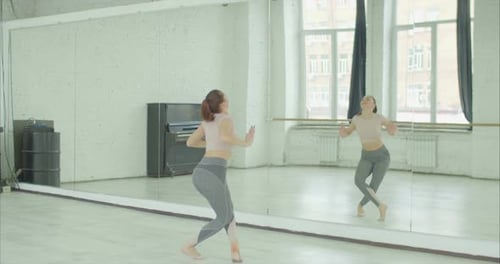 Dancer Rehearsing Dance Against Mirror at Studio