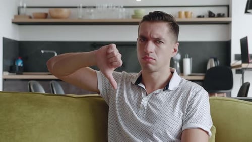 Dissatisfied Confused Young Man 30s Years Old Looking Camera Showing Thumb Down. Reaction of Reject