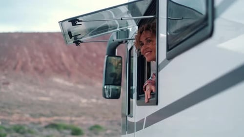 Woman Smiles from Camper Window in Desert