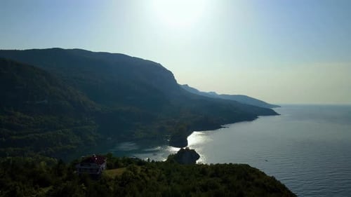 Steile grüne Berge, tiefe Wald- und Bergstraße, schönes Tal und blaues Meer