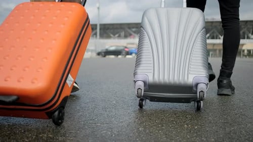 Travelers Pulling Luggage in Urban Environment