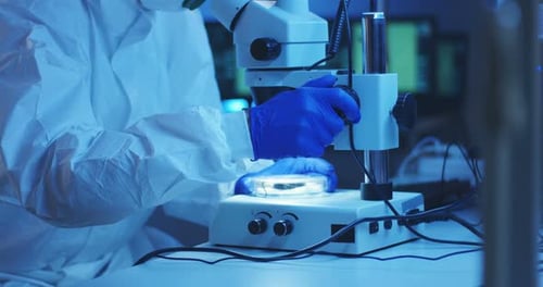 Scientist Analyzing Specimen Under Microscope in Lab