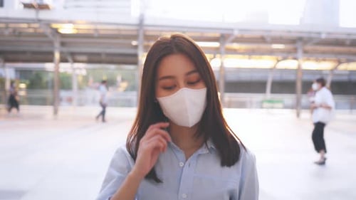Young Woman Removes Mask and Smiles in City