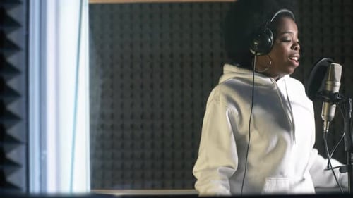 Energetic Female Singer Recording Song in Studio