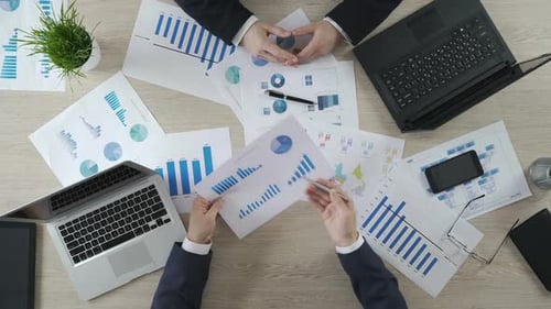 Zwei Männer überprüfen Geschäftsdiagramme, diskutieren Finanzbericht, Brainstorming