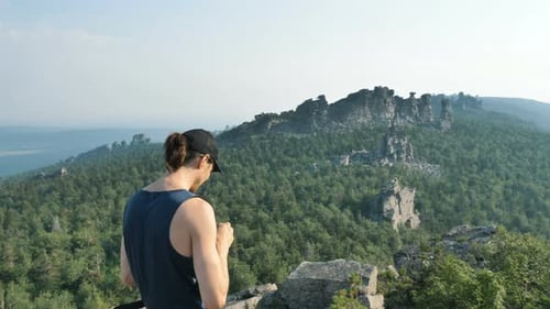 Young Man Hiking Atop Rocky Mountain Overlook
